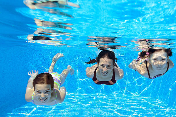 istock Three smiling girls swimming in a pool 471883313