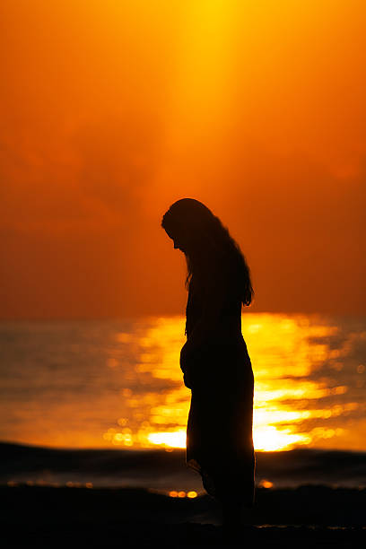moody weibliche silhouette auf romantische sunrisesunset beach - heaven women sunrise inspiration stock-fotos und bilder