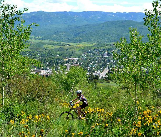 Young Mountain Biker Above Town A young mountain biker rides the trail above the town of Steamboat Springs, Colorado. steamboat springs photos stock pictures, royalty-free photos & images