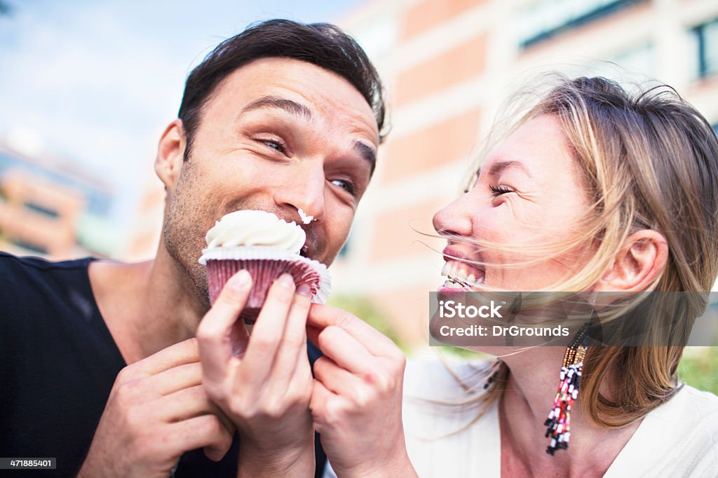 Joyful couple eating cupcake outdoors Eating Stock Photo