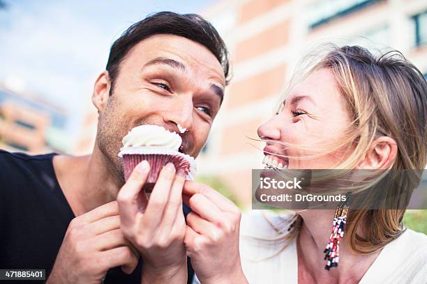 Joyful Couple Eating Cupcake Outdoors Stock Photo - Download Image Now - Eating, Cupcake, Couple - Relationship
