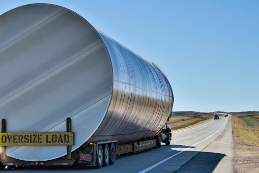 A semi hauls an oversized container on a highway in Wyoming. Nice transportation theme with space for copy.
