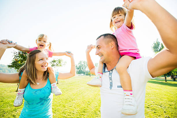 istock Parents carrying their daughters on the shoulders. 471886919