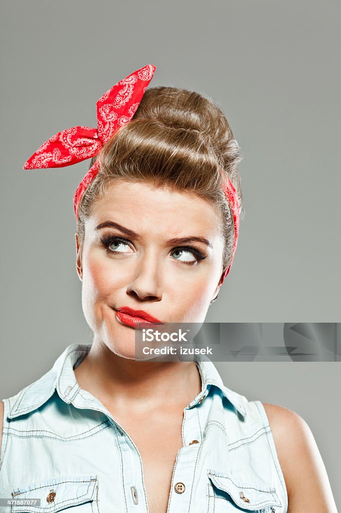 Pin-up style woman, Studio Portrait Portrait of disappointed pin-up style young woman looking up. 20-24 Years Stock Photo