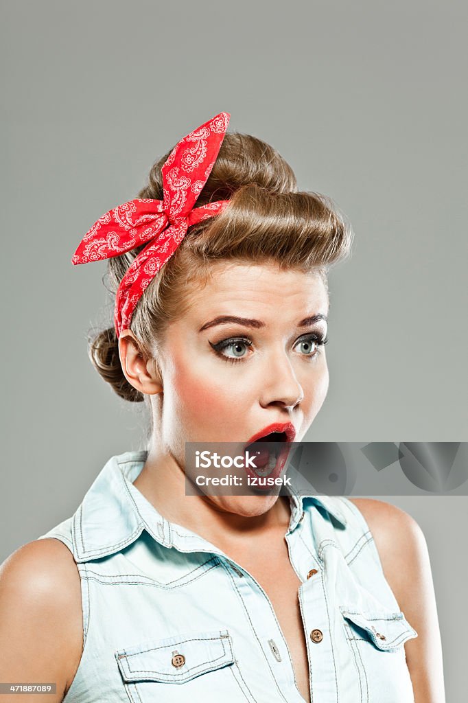 Shocked pin-up style woman, Studio Portrait Portrait of shocked pin-up style young woman looking away with mouth open. 20-24 Years Stock Photo