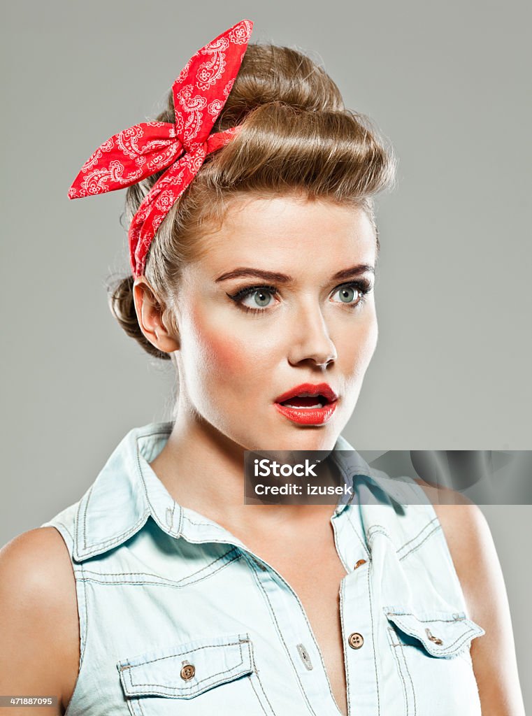 Pin-up style woman, Studio Portrait Portrait of shocked pin-up style young woman looking away with mouth open. Close-up Stock Photo
