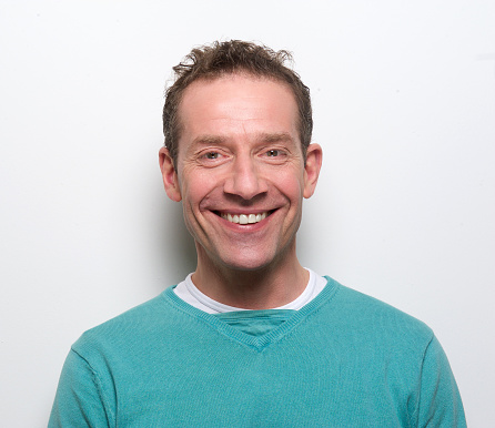 Close up portrait of a happy middle aged man smiling on white background