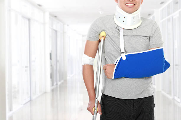 injured young man use crutch and arm sling portrait of injured young man use crutch and arm sling man with arm sling stock pictures, royalty-free photos & images