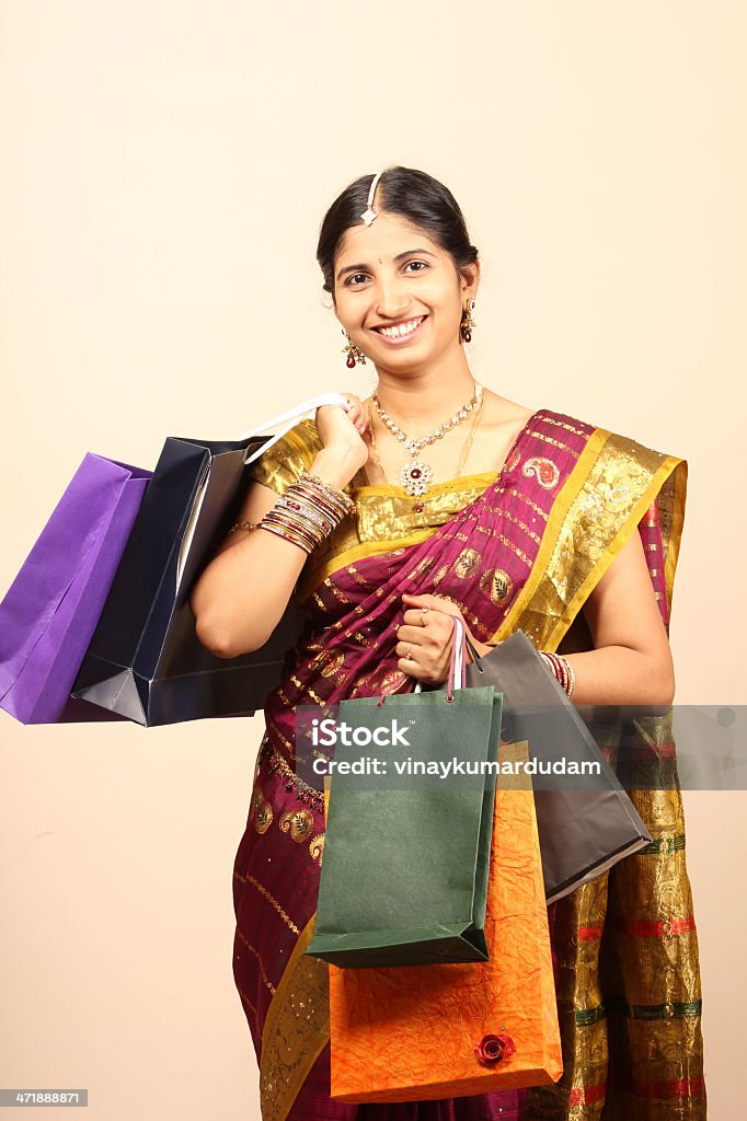 Young Indian woman with shopping bags an indoor shot of Happy young Indian traditional woman with shopping bags Adult Stock Photo
