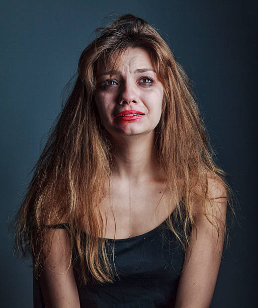 sad woman crying on black background
