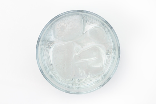 glass of water filled with ice cubes isolated on white background. refreshment drink. photo taken from directly above with DSLR camera and telephoto lens in studio. light is from bounced flash.