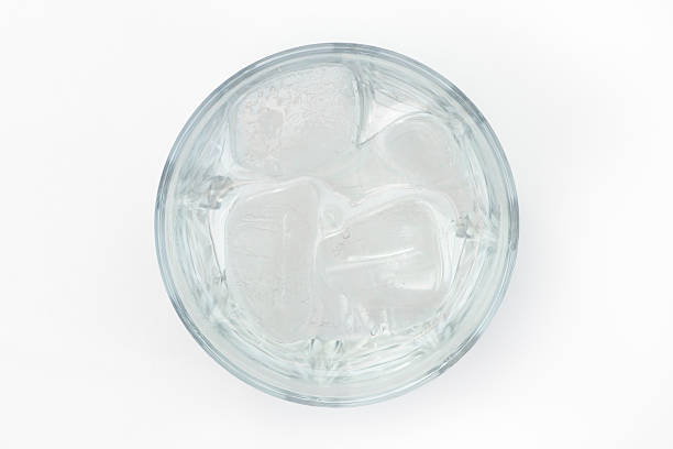 refreshment in glass of water filled with ice cubes glass of water filled with ice cubes isolated on white background. refreshment drink. photo taken from directly above with DSLR camera and telephoto lens in studio. light is from bounced flash. high section stock pictures, royalty-free photos & images