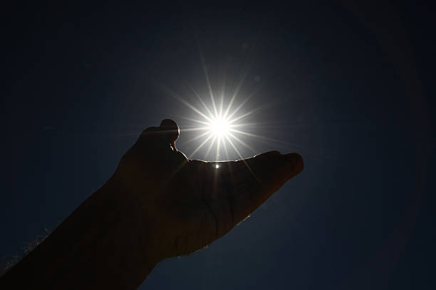 istock One Hand Catching the Sun Stars on a Blue Background 471890155