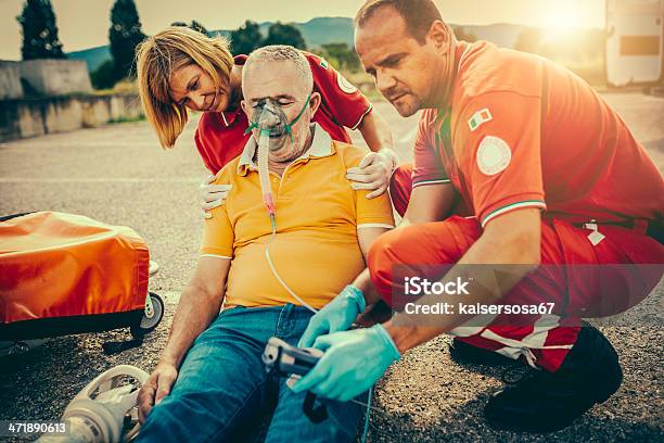 Squadra Di Soccorso Fornire Primo Soccorso - Fotografie stock e altre immagini di Evento catastrofico - Evento catastrofico, Sanità e medicina, Adulto