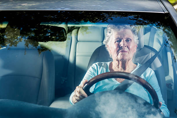 Senior woman driving car Senior woman (90s) driving car. one senior woman only stock pictures, royalty-free photos & images