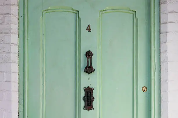 Photo of Light Green Door with iron black ornaments number four 4