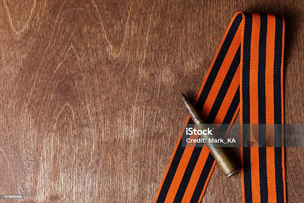 St. George ribbon and old shell Russian St. George ribbon and old shell on wooden background 2015 Stock Photo