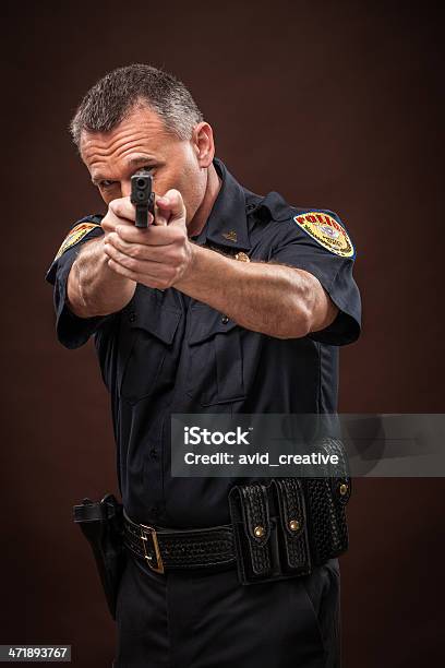 Oficial De Policía Pointing Gun Foto de stock y más banco de imágenes de Clase de formación - Clase de formación, Arma, Cuerpo de policía