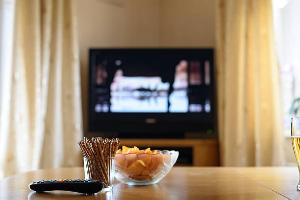 istock television, TV watching (movie) with snacks lying on table 471894262