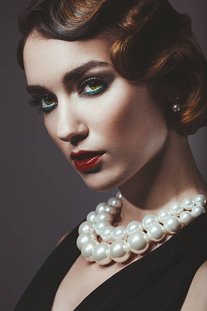 Glam retro diva Studio portrait of beautiful glamourous woman. 20's - 30's styled image. Professional make-up and hairstyle. High-end retouch. Pearl Necklaces stock pictures, royalty-free photos & images