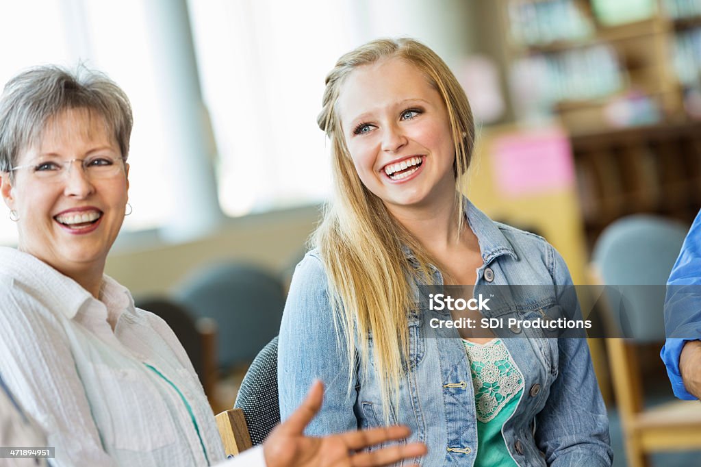 Los adolescentes y adultos hablando juntos durante el debate de la reunión - Foto de stock de Chica adolescente libre de derechos