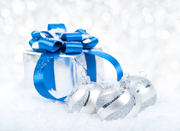 istock Christmas gift and white decorated baubles against defocused lights 471895273