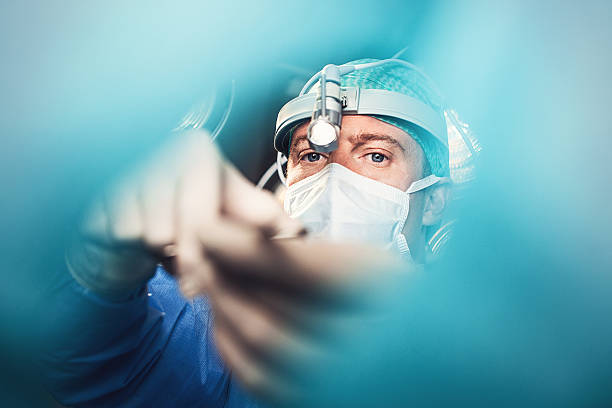 médico dando cirurgia - focus on face - fotografias e filmes do acervo