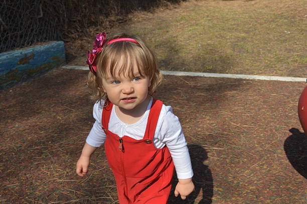 istock Naughty Blond Toddler in Red Overalls 471896654