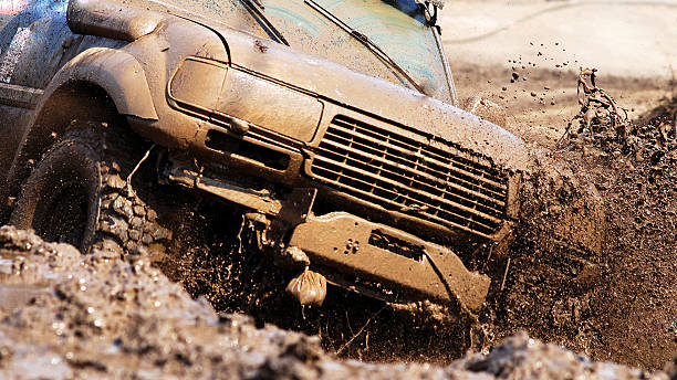 Close up of a SUV being driven through the mud stock photo