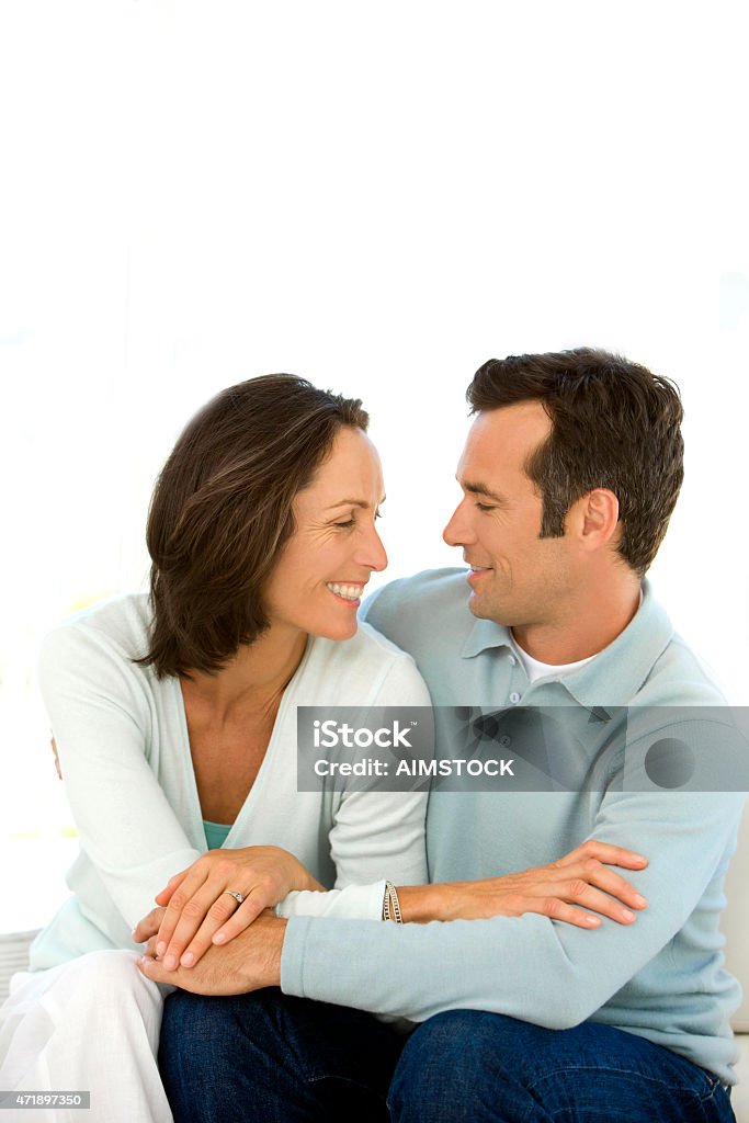 Couple in love Mature couple in love hugging on a sofa. Vertical shot with copy space. Isolated on white background. 2015 Stock Photo