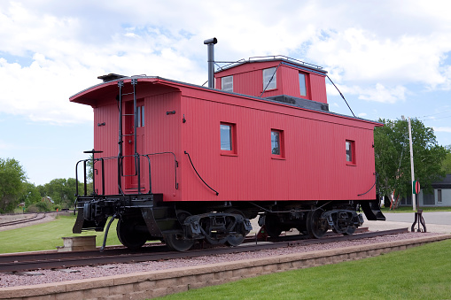 An old wooden red caboose on display.