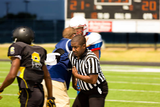 istock Sports:  Football players separated by coach, referee during game. 471897797