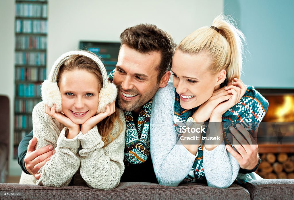 Family winter portrait Winter portrait of happy family sitting on a sofa at home, embracing and laughing,  Heat - Temperature Stock Photo