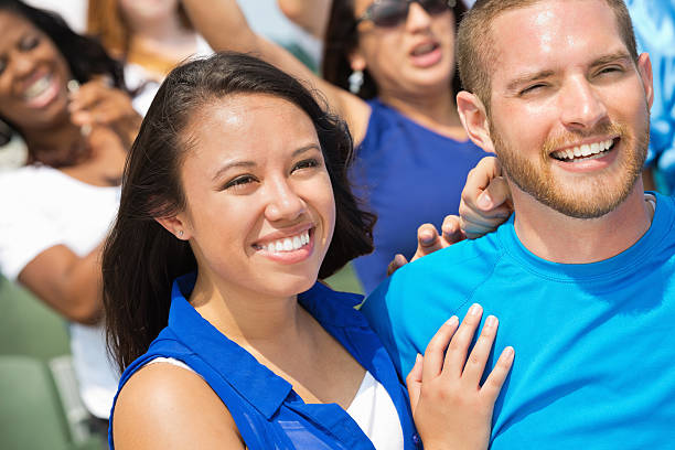 istock Happy couple watching sporting event together in crowded stadium 471898737