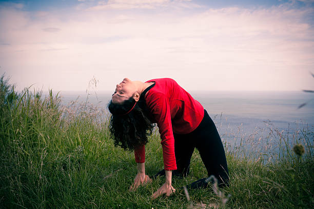 Middle age woman doing yoga exercise outdoors stock photo
