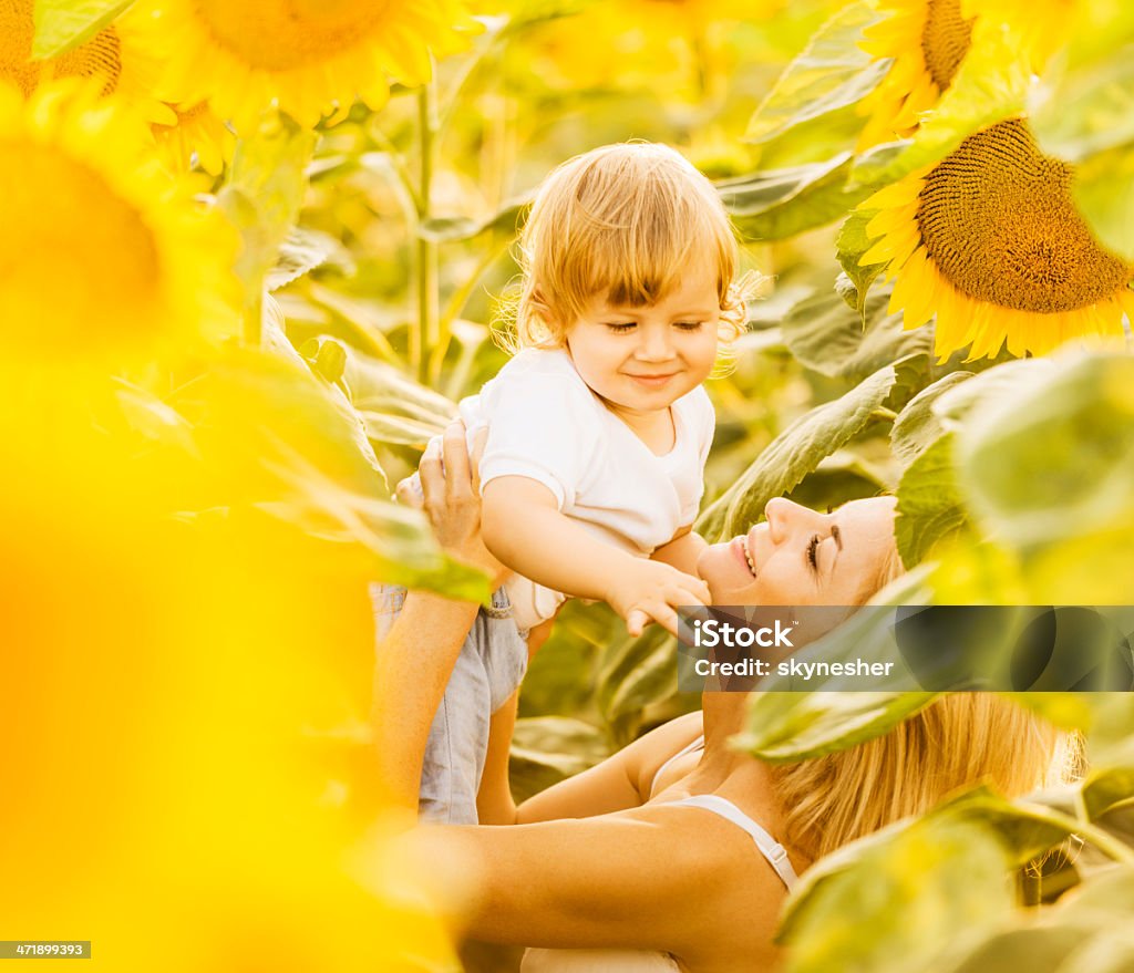 Mère avec son fils en profitant des tournesols. - Photo de 12-23 mois libre de droits