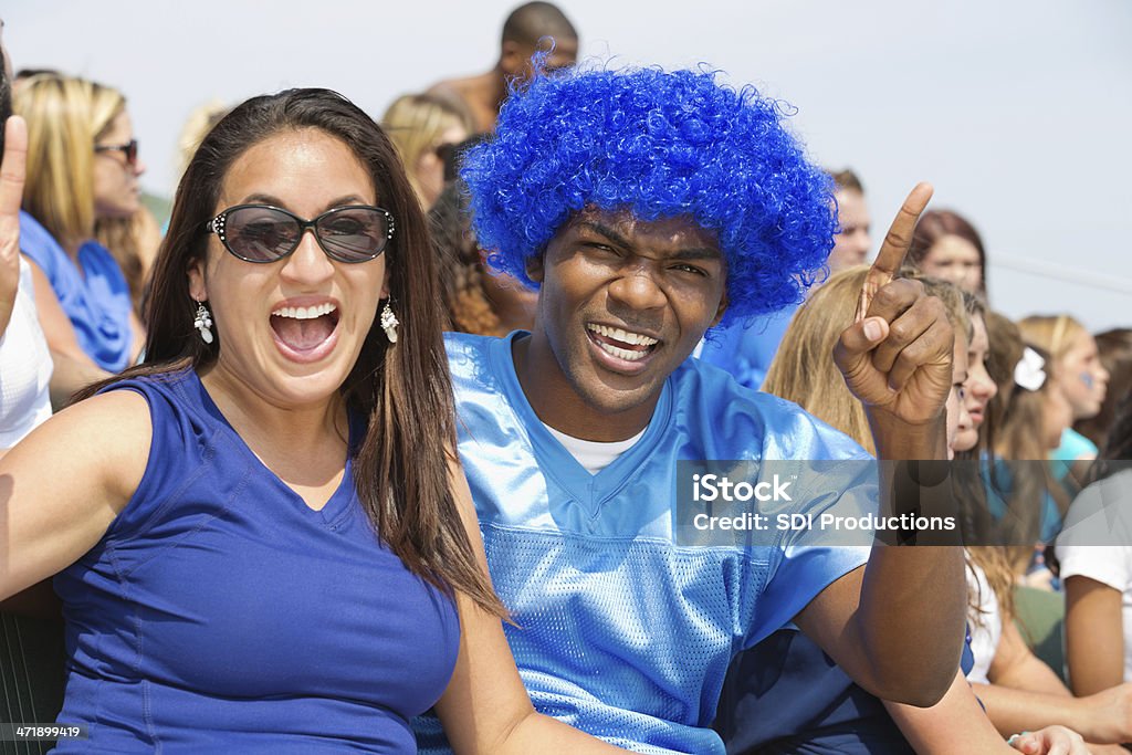 Une los fanáticos de los deportes aclamando en equipo en gradas en el estadio - Foto de stock de Aclamar libre de derechos