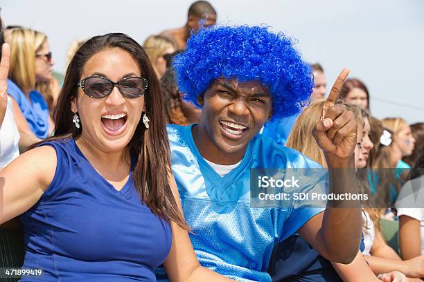 Une Los Fanáticos De Los Deportes Aclamando En Equipo En Gradas En El Estadio Foto de stock y más banco de imágenes de Aclamar