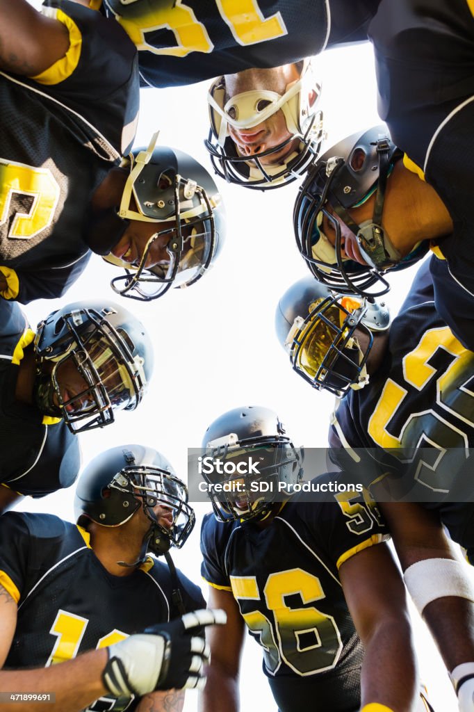 Football team huddling zusammen während game time out - Lizenzfrei Amerikanischer Football Stock-Foto