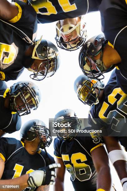 Football Team Huddling Zusammen Während Game Time Out Stockfoto und mehr Bilder von Amerikanischer Football
