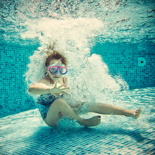 istock Little girl swimming underwater 471899719