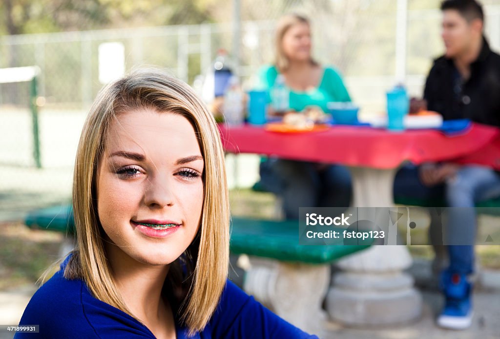 Teenagers: Blond teenage girl at family picnic. Lovely teenager girl with her family at a picnic in their local park.    20-29 Years Stock Photo