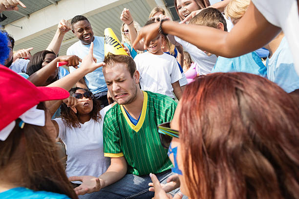 istock Crowd heckling fan of opposing team during sporting event 471900415