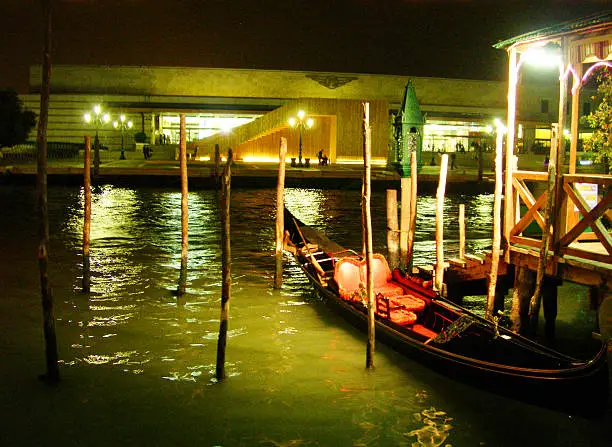 Gondolas at the dock across from station Santa-Lucia. Venetian background.