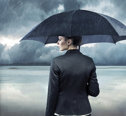 Businesswoman standing with an black umbrella