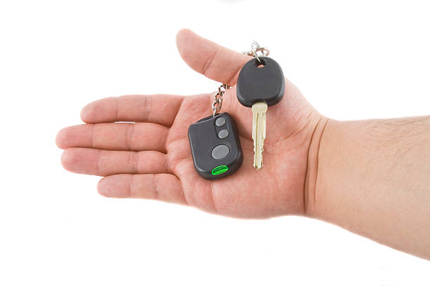 istock Hand holding key and car alarm system 471902477
