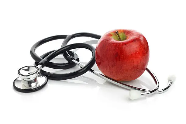 Photo of Crunchy red apple and a doctor's stethoscope