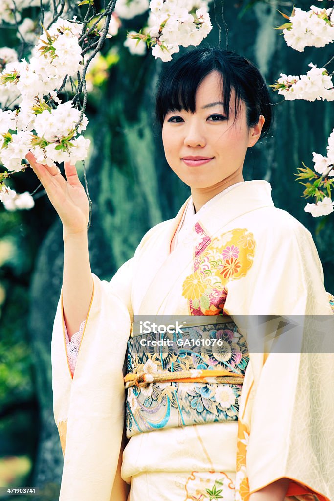 Donna in kimono con sakura ramo con fiori di - Foto stock royalty-free di Adulto