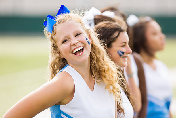 słodka cheerleaderka śmiać się, dopingować z zespołu w gry - cheerleader high school student sport cheering zdjęcia i obrazy z banku zdjęć