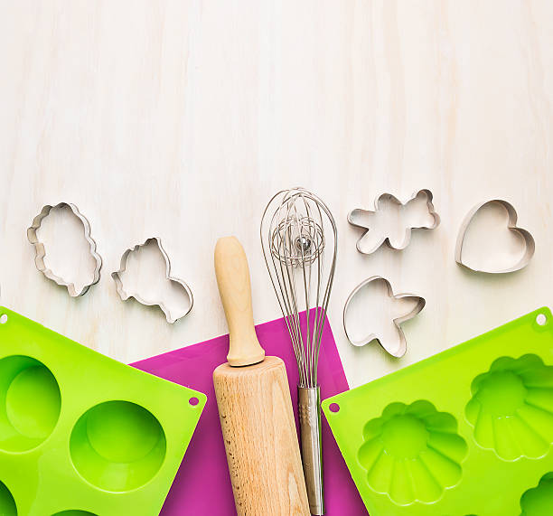 Bake tools with cake mould  and on white wooden background